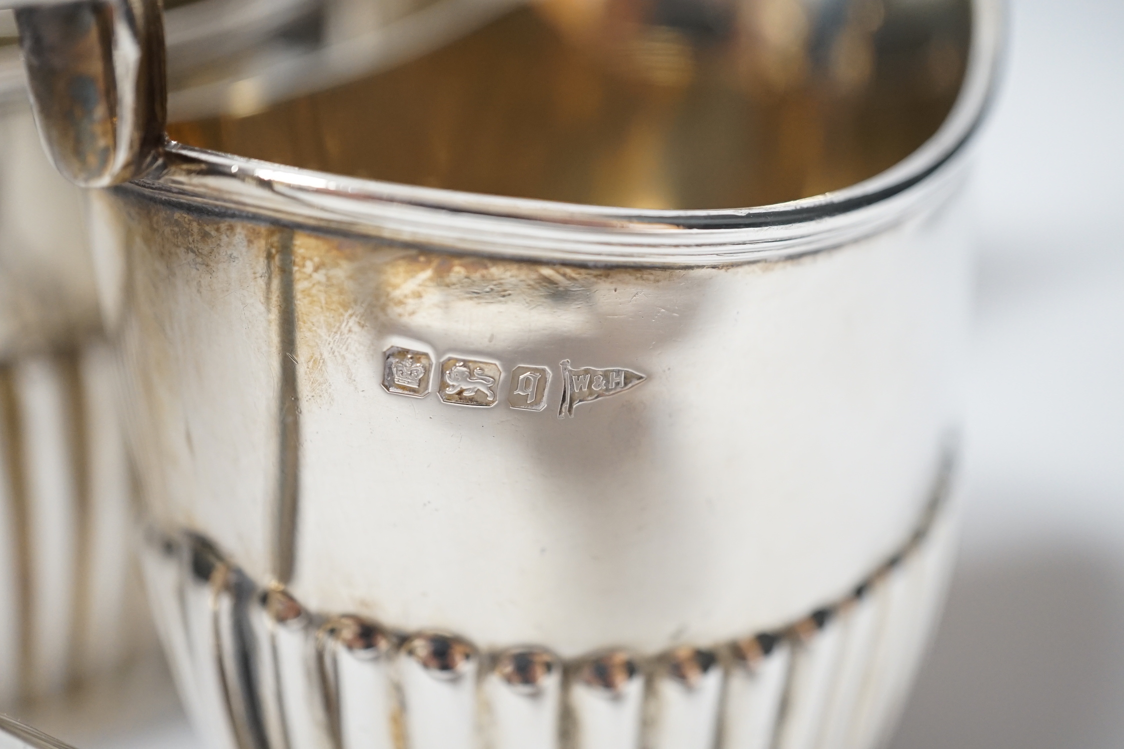 An Edwardian matched demi fluted silver five piece tea and coffee service, by Walker & Hall, Chester, 1906 and Sheffield, 1907/1908, the coffee pot and hot water jug with pedestal foot, gross weight 79.3oz.